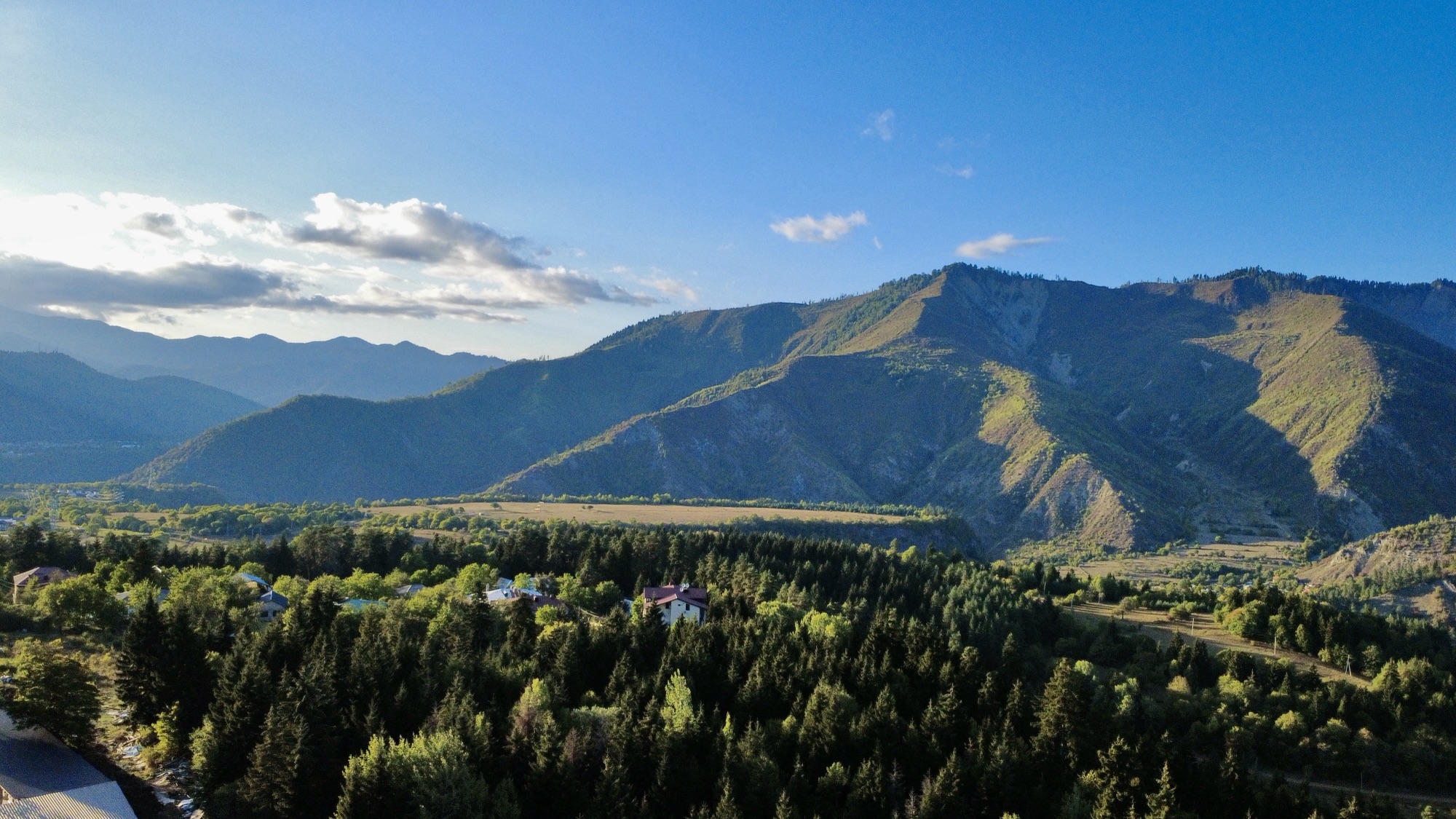 Dronefoto av kveldssol over skog og fjell i Tsemi, Georgia. 